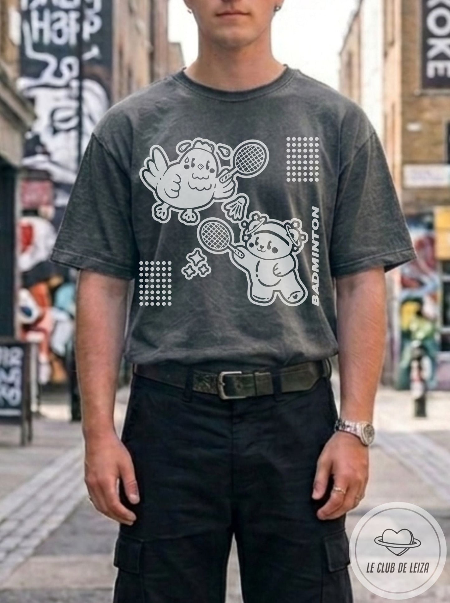 Man wearing a dark gray t-shirt with graphic design in an urban setting