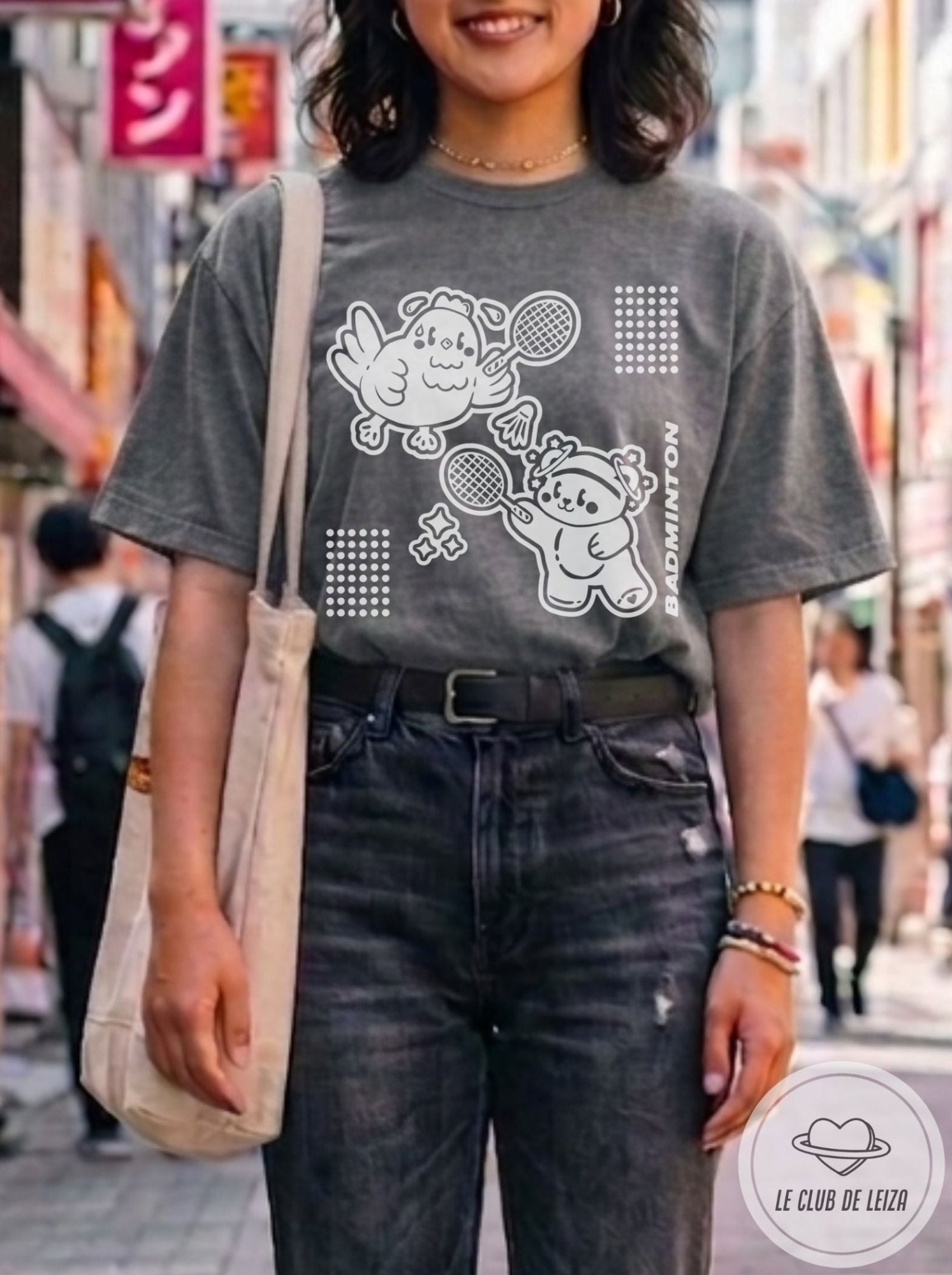 Woman wearing a dark t-shirt with cartoon designs in an urban setting